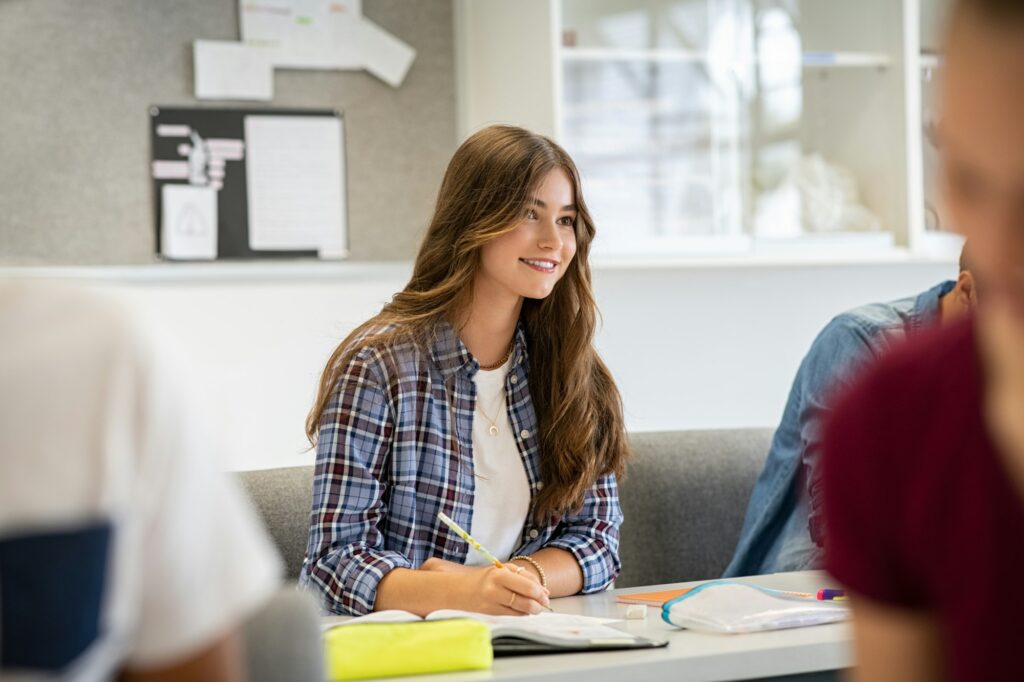 Beautiful smart girl listening lesson at high school
