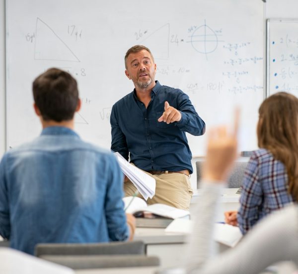 Student raising hand in classroom at the high school